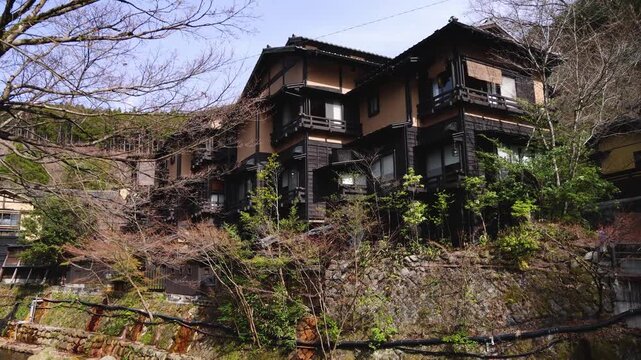 Kurokawa Onsen, hot spring resort mountain town, Kumamoto prefecture, Japan, Kyushu island, Minamioguni, Aso District, streets with traditional wooden ryokan public bath houses in a sunny day