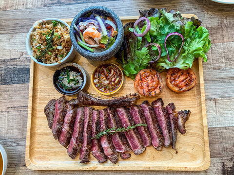 Perfect Grilled medium rare Ribeye Steak Platter with Sides and thai style sauce