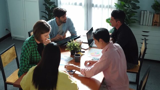 Business woman walking and hold tablet to present marketing plan to group of investor. Creative startup team discussing about financial graph and waving hand to greeting project manager. Convocation.
