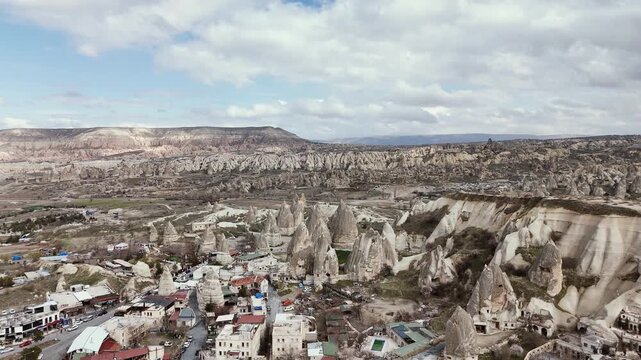 Cappadocia landscape featuring unique fairy chimney rock formations and the town of Nevsehir, Turkiye