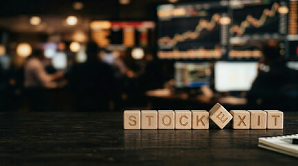 Naklejka premium Wooden blocks spelling stock exit with financial trading background, symbolizing market exit strategy and investment decisions in busy office environment