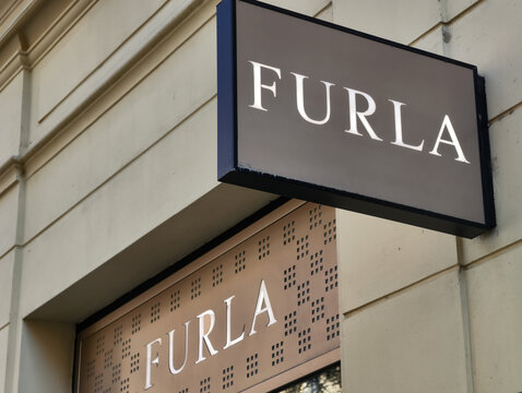Prague, Czech Republic &ndash; March 22, 2026: Furla luxury fashion accessories boutique exterior signage with projecting illuminated sign and branded fascia panel above store entrance in Prague city center