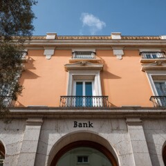 Naklejka premium Tall bank building facade with balcony windows and arched ground floor openings under a clear blue sky