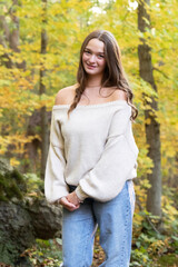 Obraz premium Young Girl in Neutral Sweater Surrounded by Fall Colors Natural Outdoor Portrait