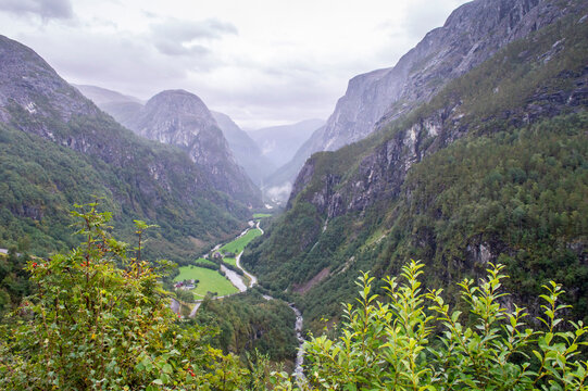 Beautiful panoramic views from Norway Stalheim Panoramic Terrace viewpoint with mountains and lush green valleys under a moody, overcast sky.  