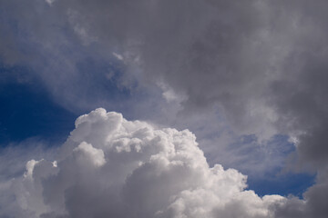 Fototapeta premium Dramatic sky with billowing white clouds and dark storm clouds