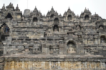 Fototapeta premium Majestic stone stupaas of the world’s largest Buddhist temple at sunrise. Ancient UNESCO heritage site showcasing intricate reliefs and statues.