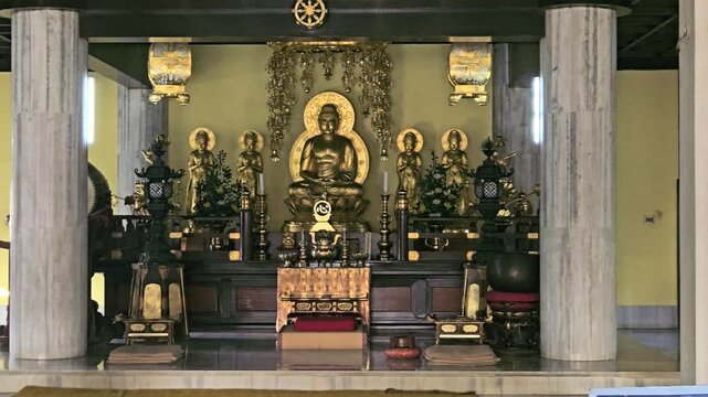 Interior of a Buddhist temple featuring a golden Buddha statue, colorful decorations, and prayer seating. Spiritual and peaceful ambiance ideal for religion, meditation, Bodh Gaya , Bihar, India