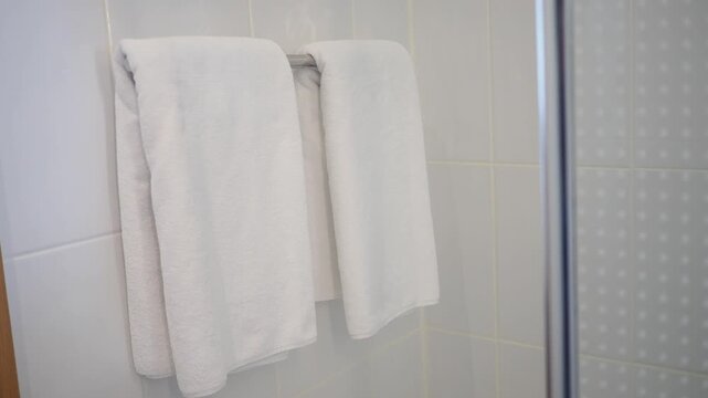 Two towels hanging in a bathroom after a shower