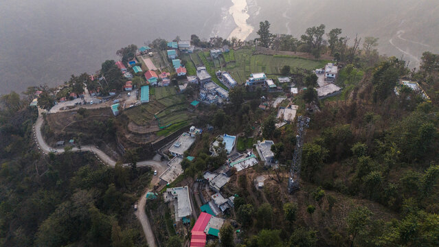 Aerial view of Kuee village in Tehri Garhwal, Uttarakhand, near Rishikesh, with the Ganga River flowing through Tota Ghati, surrounded by lower Himalayan hills and forests of sal, peepal, banyan.