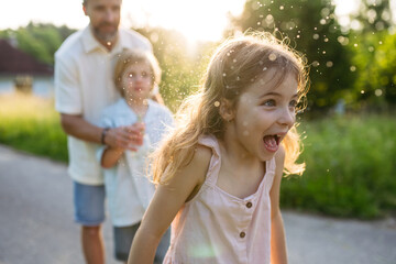 Girl running while being sprinkled with water on Easter Monday.