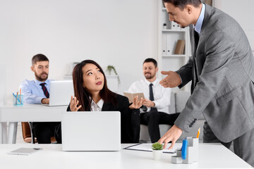 Fototapeta premium Asian businesswoman in wheelchair with colleagues working at office