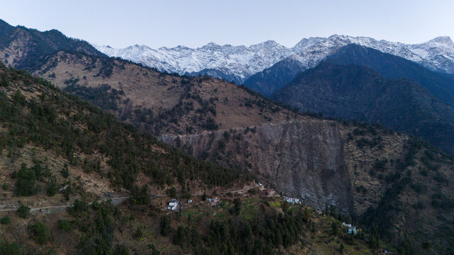 Morning landscape view from Triyuginarayan village in the Garhwal Himalayas, featuring snow-capped Kedarnath peaks, lush forests, and high-altitude terrain with pine, oak, rhododendron, & deodar trees