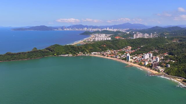 Aerial wide view of Cabe&ccedil;udas and Praia Brava with Balneario Camboriu skyline in background on sunny day.