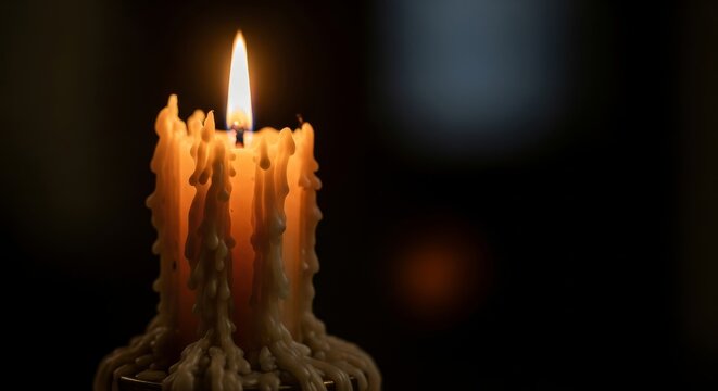 Melting candle with warm light in dark room setting
