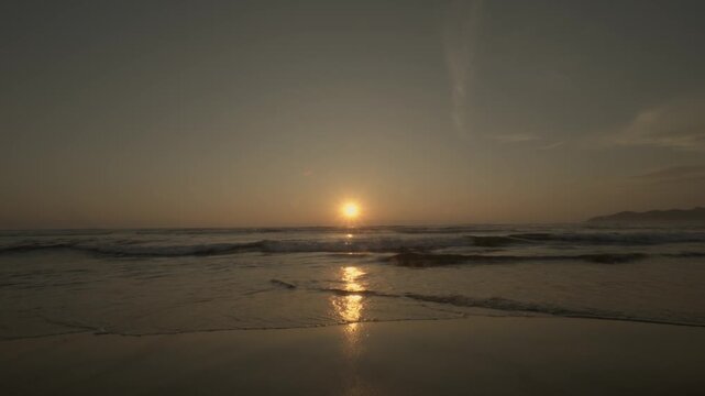Golden Sunset on Beach with Waves and Sun Reflection