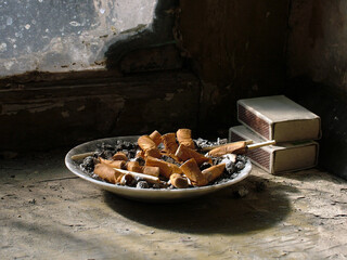 Niedopałki papierosów na parapecie przy oknie © arteffect.pl