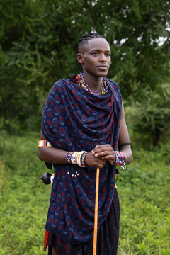 Portrait of a young Maasai warrior in the forest wearing traditional clothing 