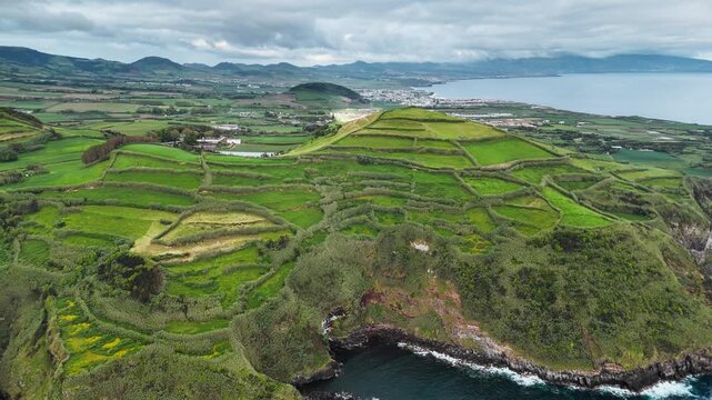 Patchwork agricultural fields above rocky Atlantic coastline on Sao Miguel Island, Azores. Aerial view