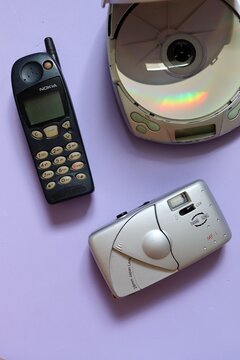 Salvador, Brazil - March 27, 2026: Old Nokia 5120, discman and analogue camera on purple background. Vintage 1990s concept. 