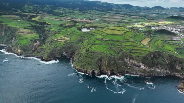 European agricultural patchwork fields bordering rocky Atlantic coastline on Azores Islands. Aerial view