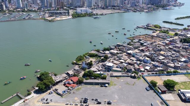 Aerial drone push forward revealing Itajai city, Itajai Acu River and port with urban and maritime infrastructure.