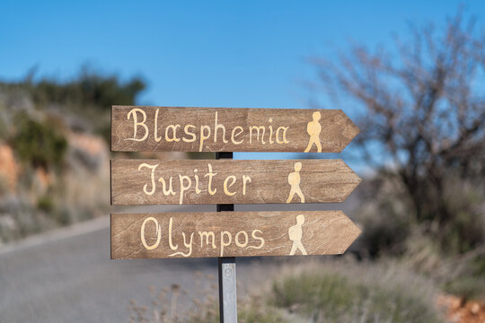 Wooden signpost pointing to climbing sectors Blasphemia, Jupiter and Olympos near Leonidio in Greece. Popular rock climbing destination.