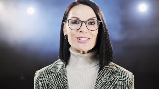 Confident female entrepreneur presenting innovative ideas on stage at a professional business conference. Engaging with the audience, she speaks under spotlights with atmospheric smoke creating a