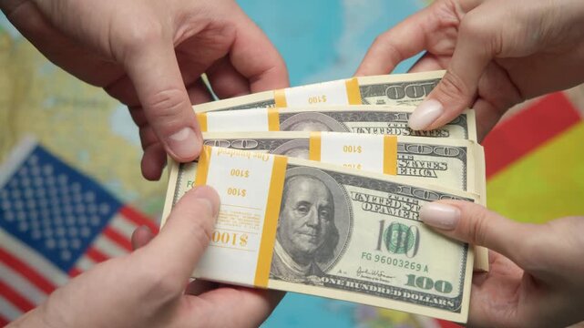 Hands pass stack of US dollars to Spain representative against world map with American and Spanish flags, symbolizing sponsorship.