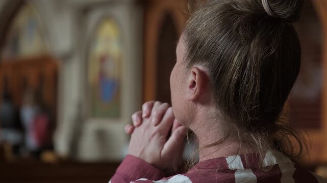 Portrait of woman parishioner praying in prayer hall at church