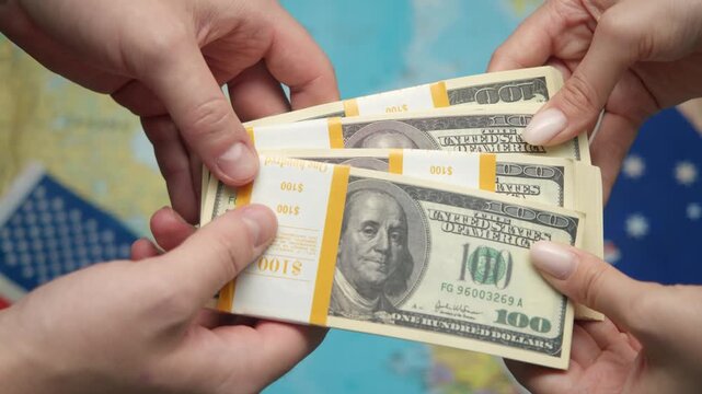 American official passes stack of dollars to Australian representative against world map with US and Australian flags for resource cooperation.
