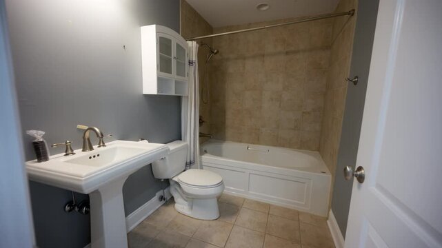 Outdated bathroom with sink, toilet, and bathtub showing worn design before renovation.