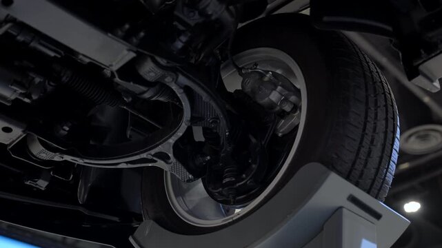 Bottom view of new car at service station showing suspension and chassis, Close up view of wheel