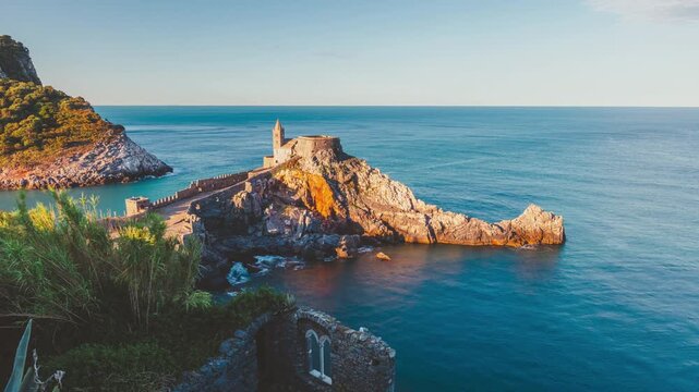 Porto Venere, Italy: 4K static timelapse of the ancient San Pietro church on the cliffs during a soft sunrise at dawn.
