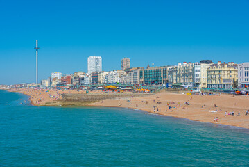 Obraz premium People are enjoying a sunny day on a beach in Brighton, England