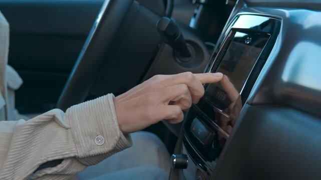 Businessman interacting with car navigation system. Businessman inside a modern car is interacting with the navigation system, touching the screen and using gestures to browse the map
