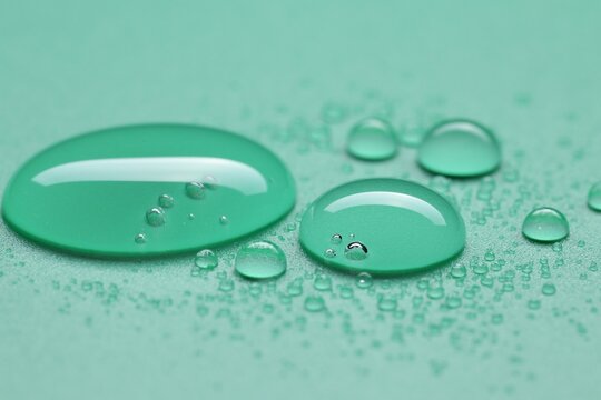 Many water drops on green background, selective focus