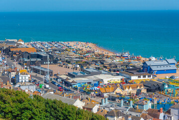 Naklejka premium People are enjoying a sunny day on a beach in Hastings, England