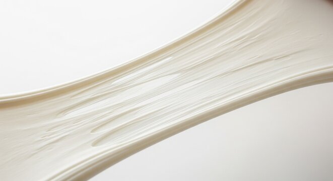 A wide shot of a thick, off-white elastic material being pulled apart, showing its high viscosity and stretchy texture.
