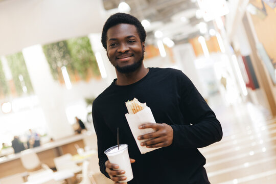 Portrait Young african male enjoying fast food doner in shopping mall