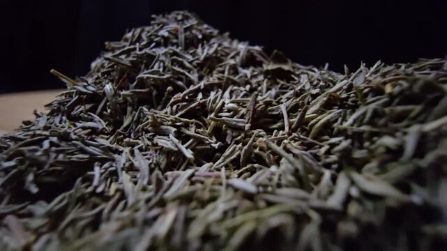 Extreme macro close-up of dried thyme leaves on a wooden surface with a black background. Slow cinematic probe lens movement revealing intricate textures and herbal details.