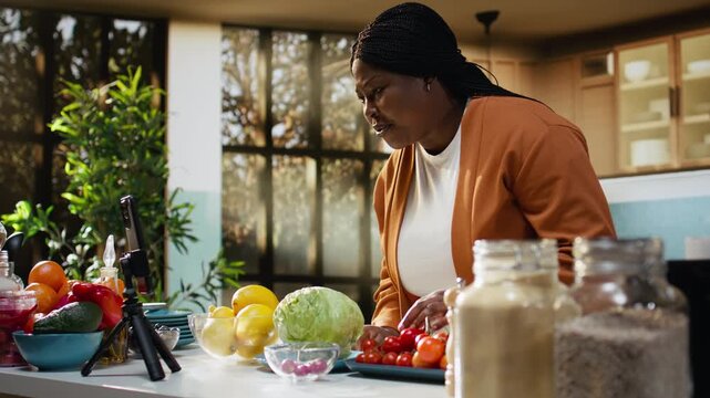 African american woman, answering questions, comment section, influencer engaging with audience after filming video. Content creator recording homemade food vlog, making a recipe.