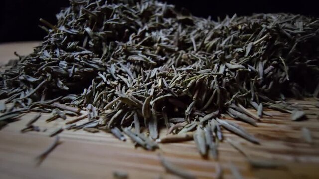 Extreme macro close-up of dried thyme leaves on a wooden surface with a black background. Slow cinematic probe lens movement revealing intricate textures and herbal details.