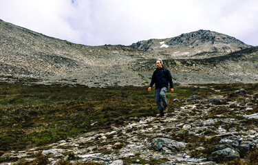 Fototapeta premium Traveler hiking and returning through the rocky slopes of Cerro del Medio back to Ushuaia city