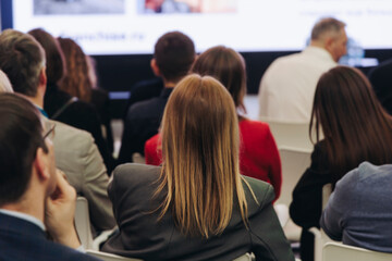 Obraz premium Conference hall with audience, panel discussion at forum, people on a congress together listen to speaker on stage at convention, plenary session at business lecture seminar, venue for presentation