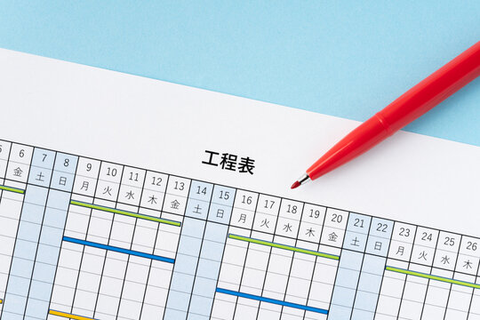 水色背景に工程表と赤いペン
