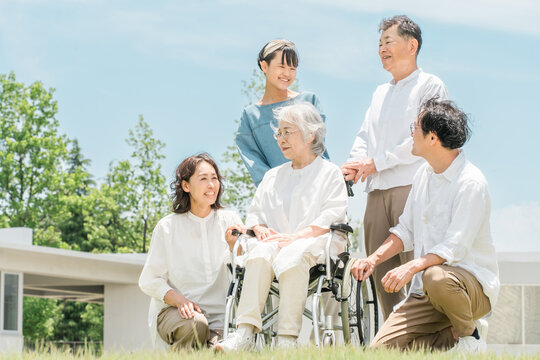 A three-generation family visiting a senior care facility or hospital.