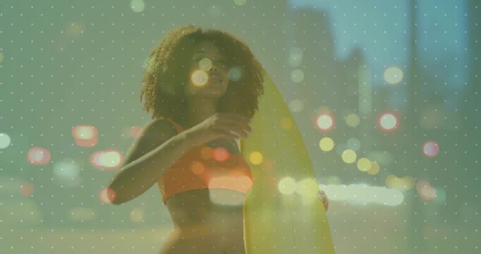 Woman holding surfboard on beach, shading eyes from sun while looking horizon, bokeh adding travel