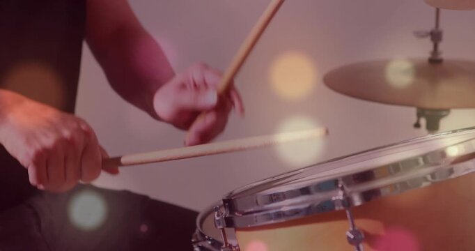Drummer tapping snare and cymbal with sticks in music studio, first tap starting bokeh peaking beat