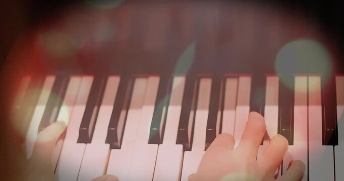 Pianist hands touching keys, shifting right and playing arpeggios to shape music, bokeh reacting